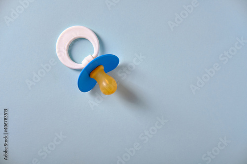 Baby blue pacifier on a blue background, place for an inscription photo