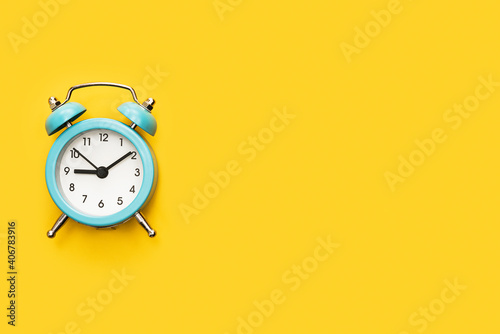 Classic alarm clock on a yellow background.
