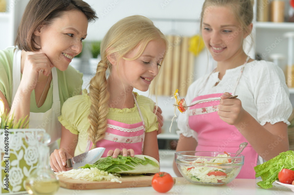 Portrait of cute girls with mother cooking in kitchen Portrait of cute girls with mother cooking in kitchen