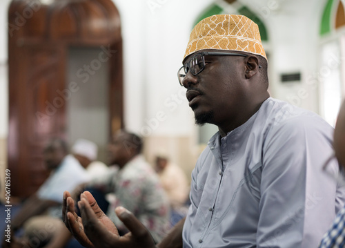 Black Muslim adult man praying inside mosque on Friday