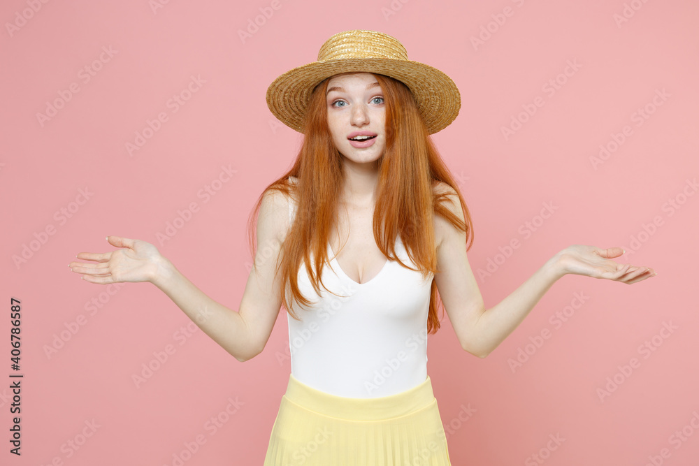Young shy mistaken pensive uncertain caucasian redhead woman ginger long hair wear straw hat summer clothes spreading hands looking camera isolated on pastel pink color background studio portrait Young shy mistaken pensive uncertain caucasian redhead woman ginger long hair wear straw hat summer clothes spreading hands looking camera isolated on pastel pink color background studio portrait