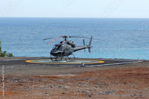 Helicopter on the helipad against the background of the sea. 