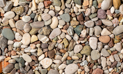 Round beach pebbles texture, close-up. Colorful stone background.
