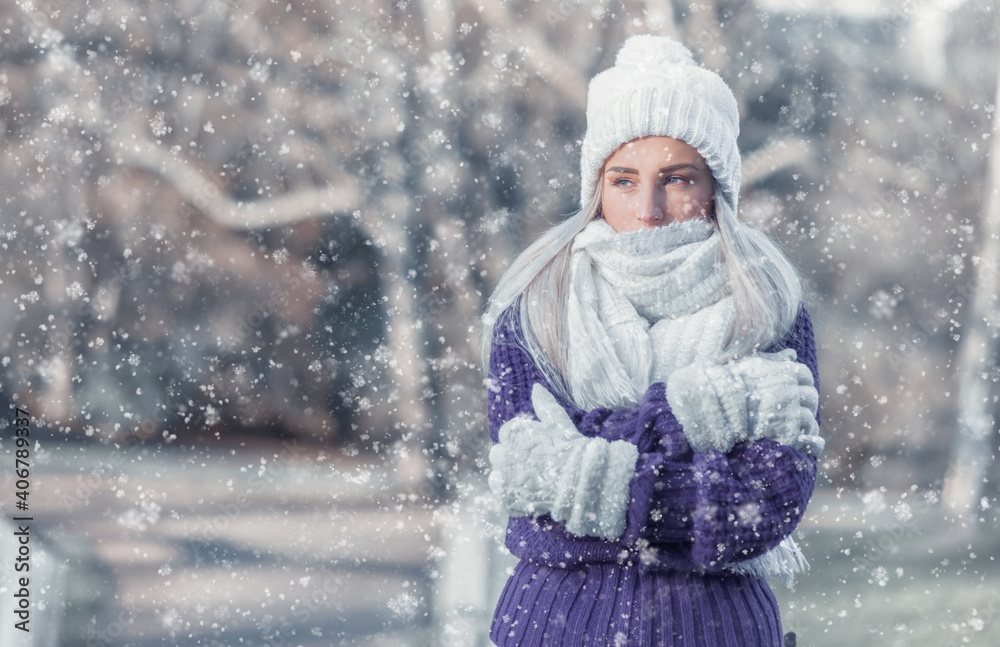 Beautiful young woman wearing warm clothing in snowflakes and winter day outdoors. Half length of cute girl wearing wool cap, scarf and purple sweater. Beautiful young woman wearing warm clothing in snowflakes and winter day outdoors. Half length of cute girl wearing wool cap, scarf and purple sweater.