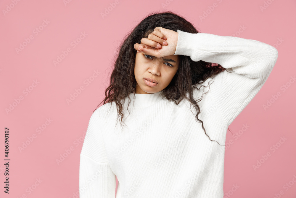 Naklejka premium Young tired sick ill exhausted troubled african american woman curly hair in white casual knitted sweater look camera touch forehead having headache isolated on pastel pink background studio portrait