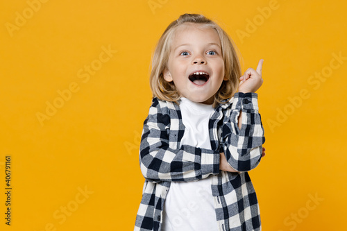 Little cute fun happy blond long-haired kid boy 5 years old wearing casual clothes posing isolated on bright yellow wall color background children studio portrait. People childhood lifestyle concept photo