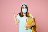 Shocked young woman student in t-shirt hat backpack face mask to safe from coronavirus virus covid-19 spreading hands isolated on pink background. Education in high school university college concept.