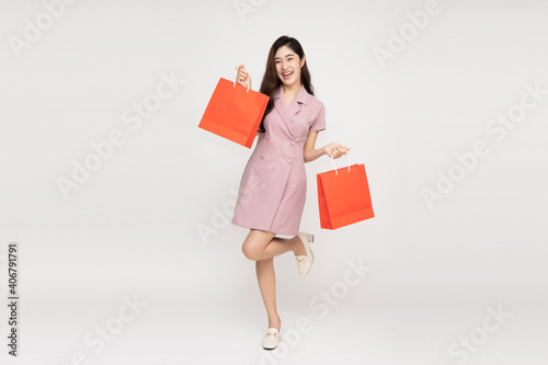 Asian woman holding shopping bags in full body isolated on white background, Shopper or shopaholic concept