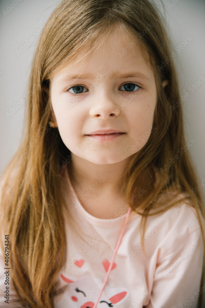 Little girl in pink pajamas sits near the window. Quarantine. Lockdown. Little girl in pink pajamas sits near the window. Quarantine. Lockdown.