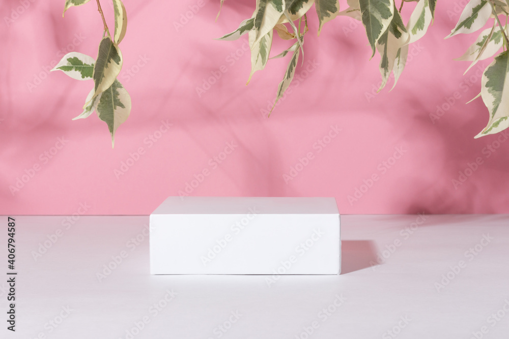 Showcase for cosmetic products. Product advertisement. Layout style design. White empty podium on a pink background with leaves and shadows. Natural cosmetics and beauty concept