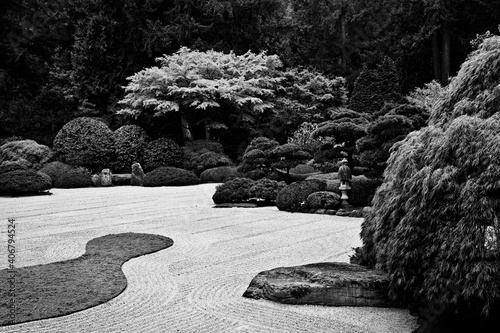 A black and white image of the Flat Garden in the Portland Japanese Garden.  The Flat Garden is made up of raked stones surrounded by a lush, carefully manicured landscape photo