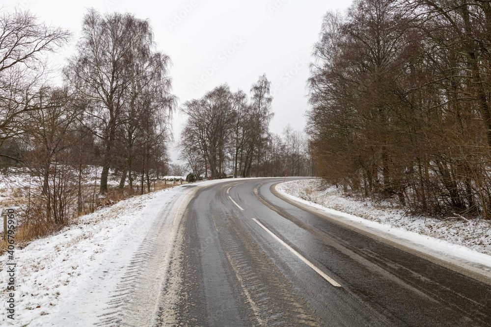 Country road with a bend in a frozen rural landscape Country road with a bend in a frozen rural landscape