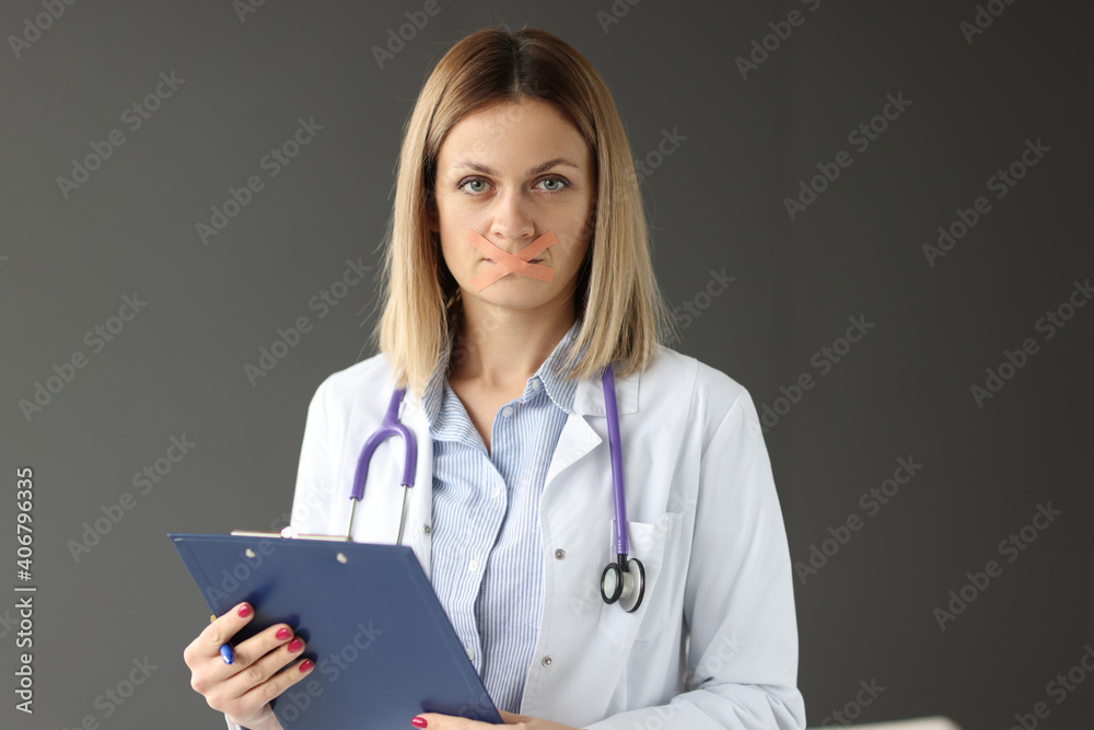 Doctor with clipboard in his hands and tape sealed over his mouth Doctor with clipboard in his hands and tape sealed over his mouth