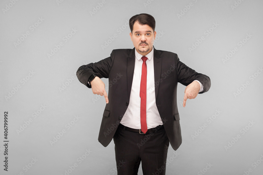 Now that you look down. indoor studio shot. isolated on gray background. handsome businessman with black suit, red tie and mustache looking at camera. Now that you look down. indoor studio shot. isolated on gray background. handsome businessman with black suit, red tie and mustache looking at camera.