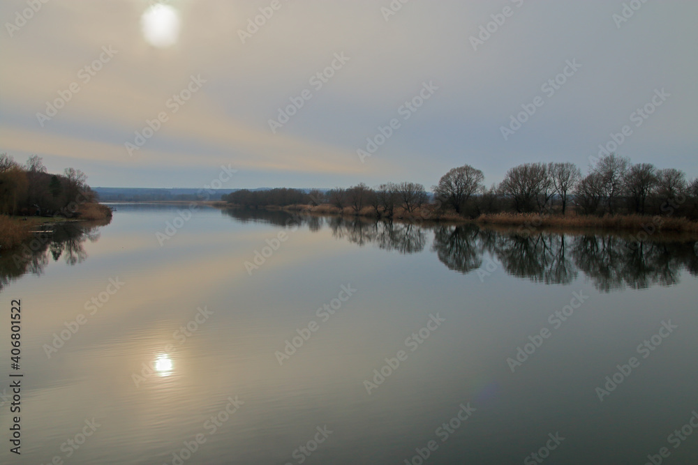 Fototapeta premium Calm river on a cloudy winter day.
