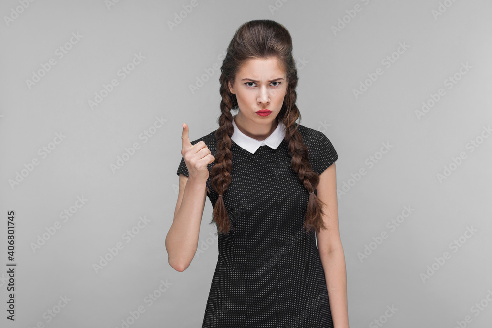 Warning sign. Teacher woman looking at camera, attention sign. Indoor, studio shot isolated on gray background Warning sign. Teacher woman looking at camera, attention sign. Indoor, studio shot isolated on gray background