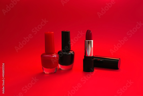 Red and black nail polish, red lipstick isolated on red background. Beauty, fashion, care concept. © NATALYA