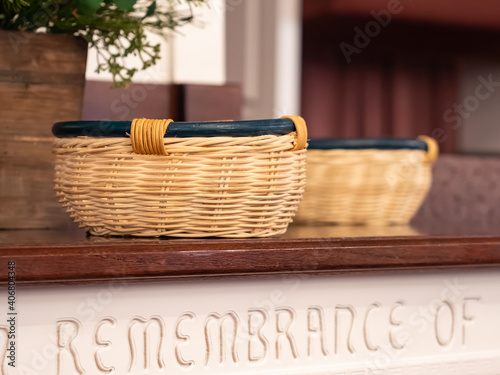 Offering baskets resting on a wooden table in front of the church pulpit