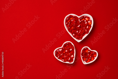 Three small heart-shaped plate with small hearts inside. Valentines day concept or postcard. Holiday symbol. Space for text. Top view.