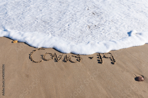 Corona virus written at the beach