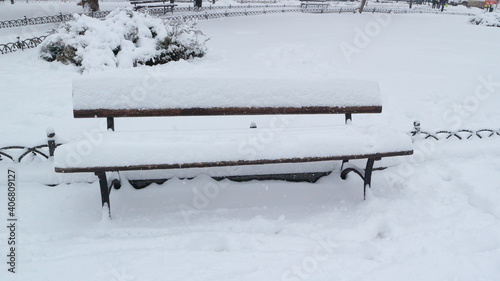 Snow-covered bench in one of the city squares