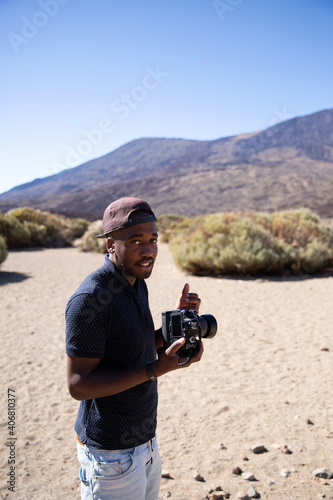 Photographer holds his camera in his hand while he is doing a photo session in the middle of the desert 