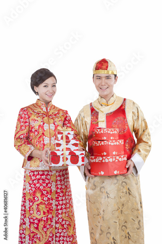 Portrait of young couple in Tang suits holding gifts