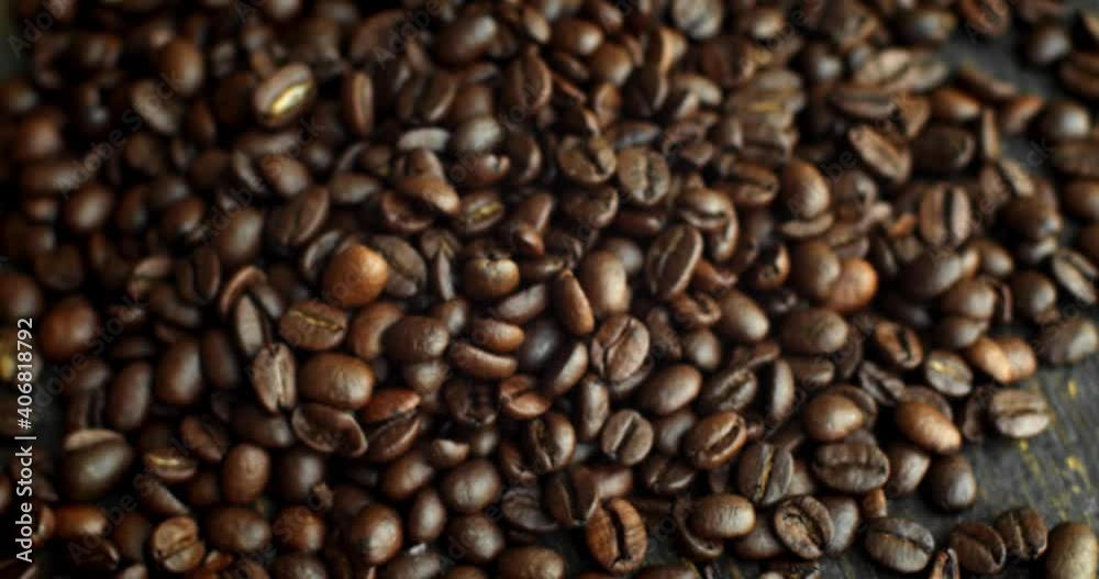 Roasted arabica coffee beans scattered on a wooden table. Fresh coffee beans. Espresso, americano, doppio, cappuccino, latte. Robusta. Selective focus. Roasted arabica coffee beans scattered on a wooden table. Fresh coffee beans. Espresso, americano, doppio, cappuccino, latte. Robusta. Selective focus.