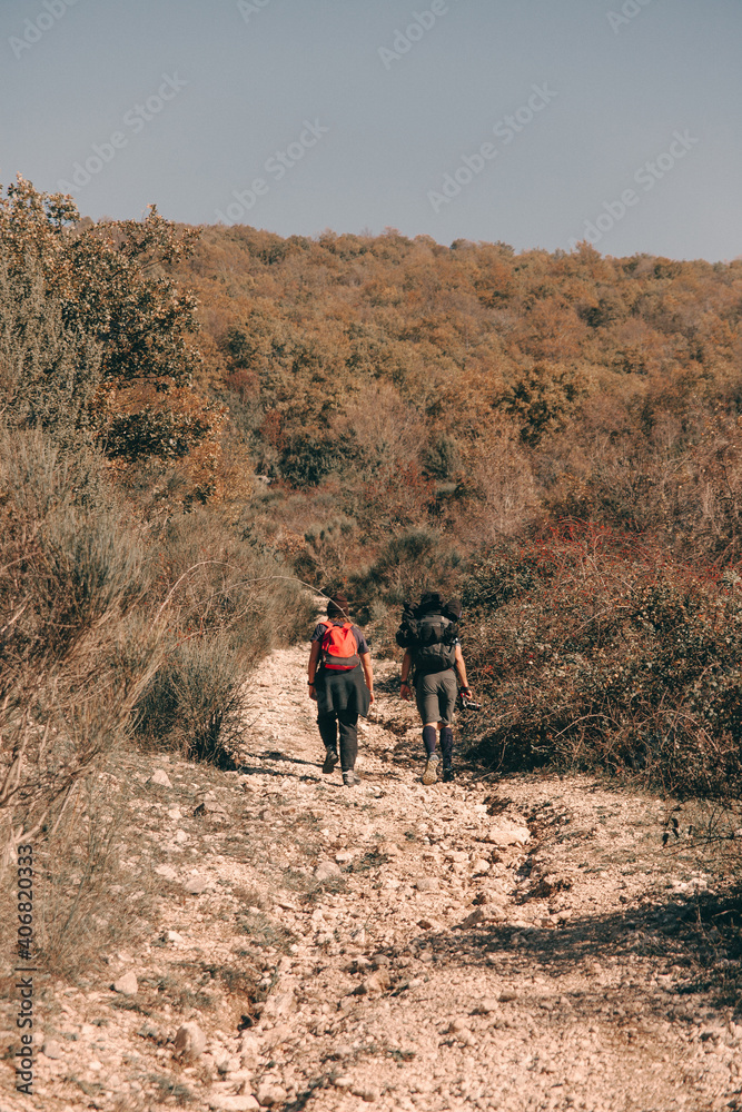 Two young friends go trekking in the mountains during the autumn time
