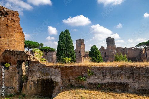 Ruins of the Baths of Caracalla the most important baths of Rome at the time of the Roman Empire. The grandiose ruins of the majestic brick walls with blue sky vegetation, Rome, Lazio, Italy. photo