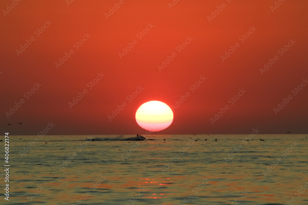 man enjoys life while riding a water bike on the background of a sunset in the sea