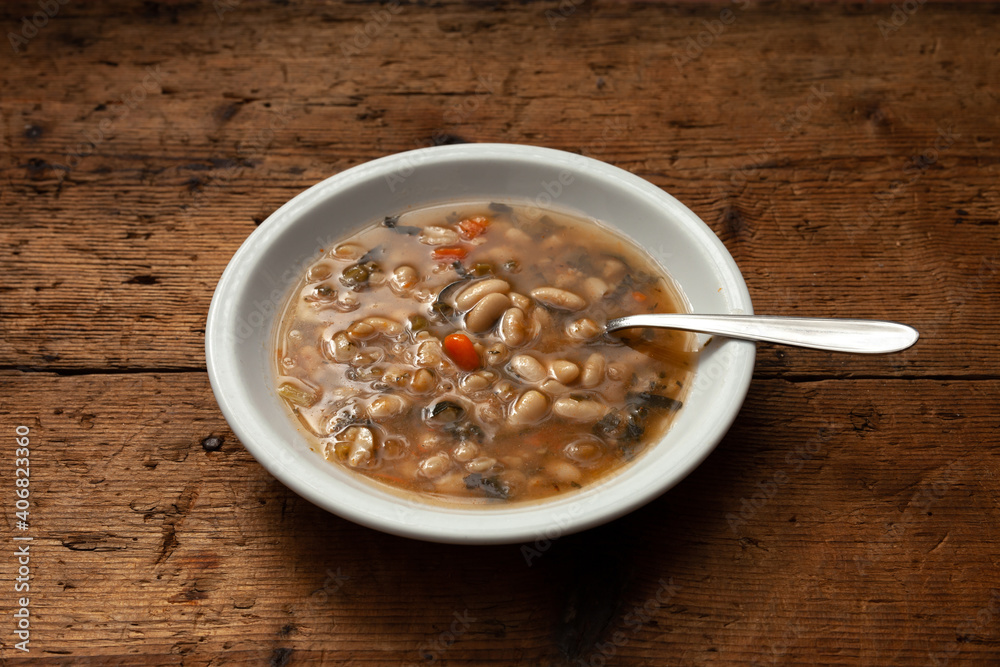 typical dish of Tuscan minestrone on wooden table typical dish of Tuscan minestrone on wooden table