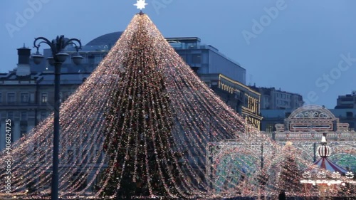 Big carousel panoramic shot on the Red Square in Moscow.Christmas market and decorations in the city.Big christmas tree on Manezhnaya Square.Tverskaya street on background