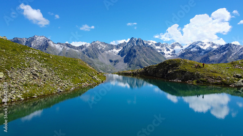 Perler See Bergsee in den Alpen  Berge mit See und blaues Wasser in Felsen mit Gr  n und Schnee beim Wandern f  r eine Auszeit und Erholung bei blauem Himmel