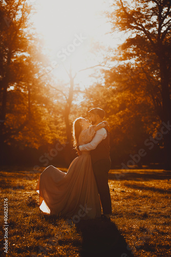 Lovely just married couple embracing outdoor during sunset in nature.