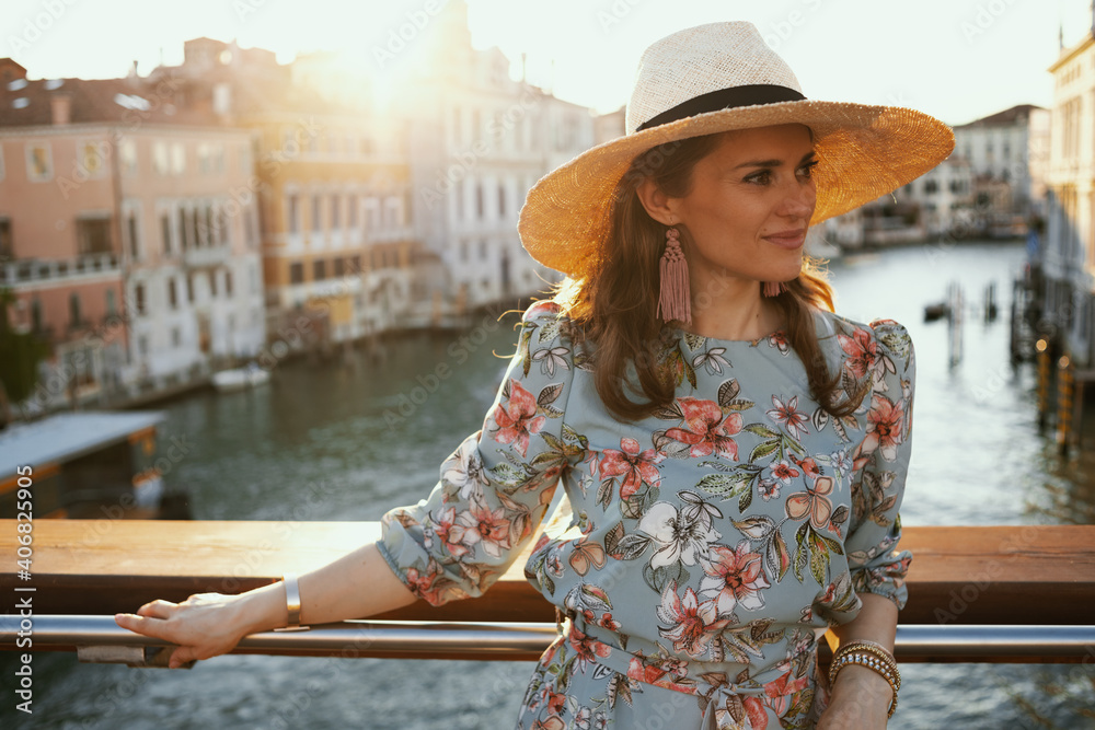 relaxed young woman in floral dress with hat having excursion