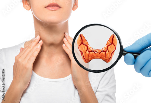 Diagnosis and treatment of thyroid diseases. Endocrinology, anatomical model of the thyroid gland over a female patient background. Thyrotoxicosis and hypothyroidism photo