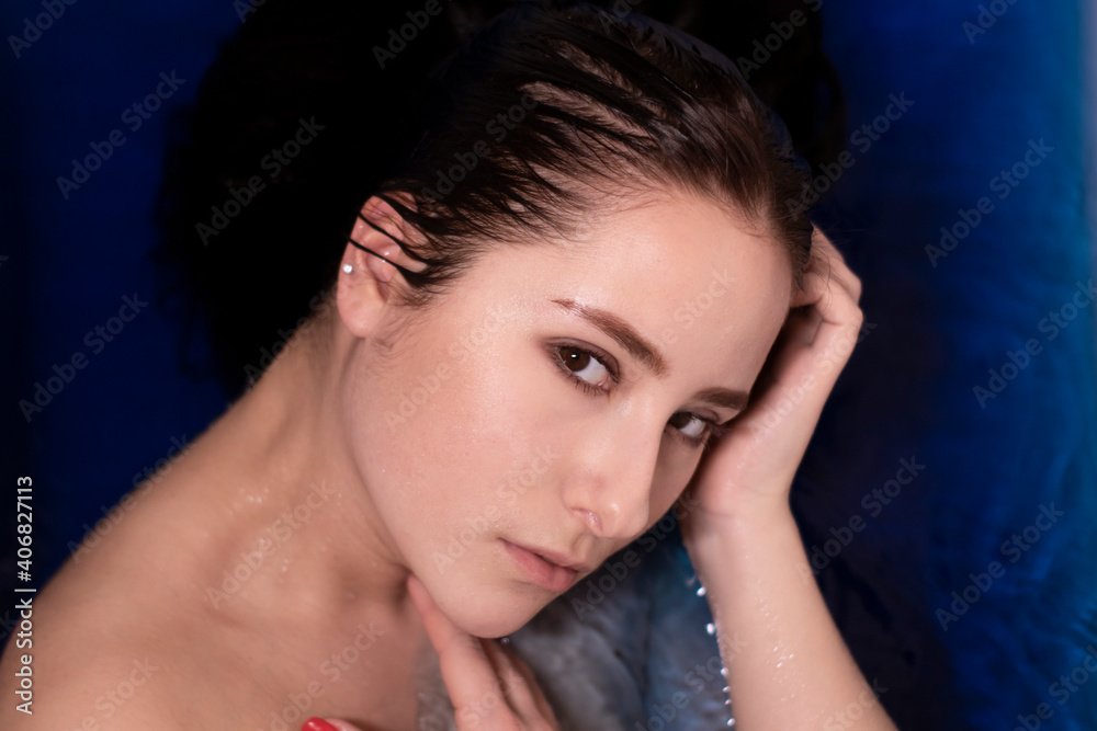portrait of attractive brunette woman topless in blue liquid. in bathtub with colored water. drowning girl portrait of attractive brunette woman topless in blue liquid. in bathtub with colored water. drowning girl