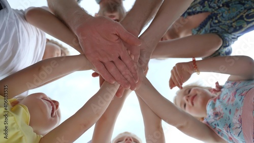 A friendly family will join hands against the background of the sky.