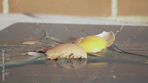 Egg breaking on table. Egg explosion in slow motion on gray table.