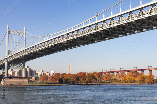 The Triborough Bridge over the East River with the Shore of Randalls and Wards Islands during Autumn with Colorful Trees in New York City