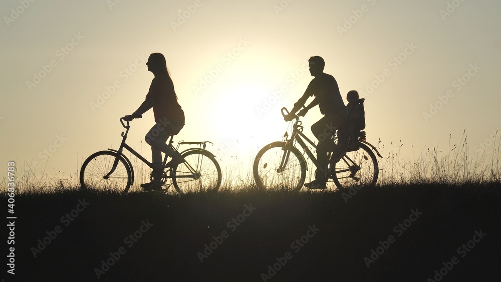 Fototapeta premium Friendly family with a child on bicycles during sunset.