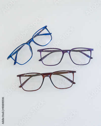 Progressive glasses with different colored frames on a white table