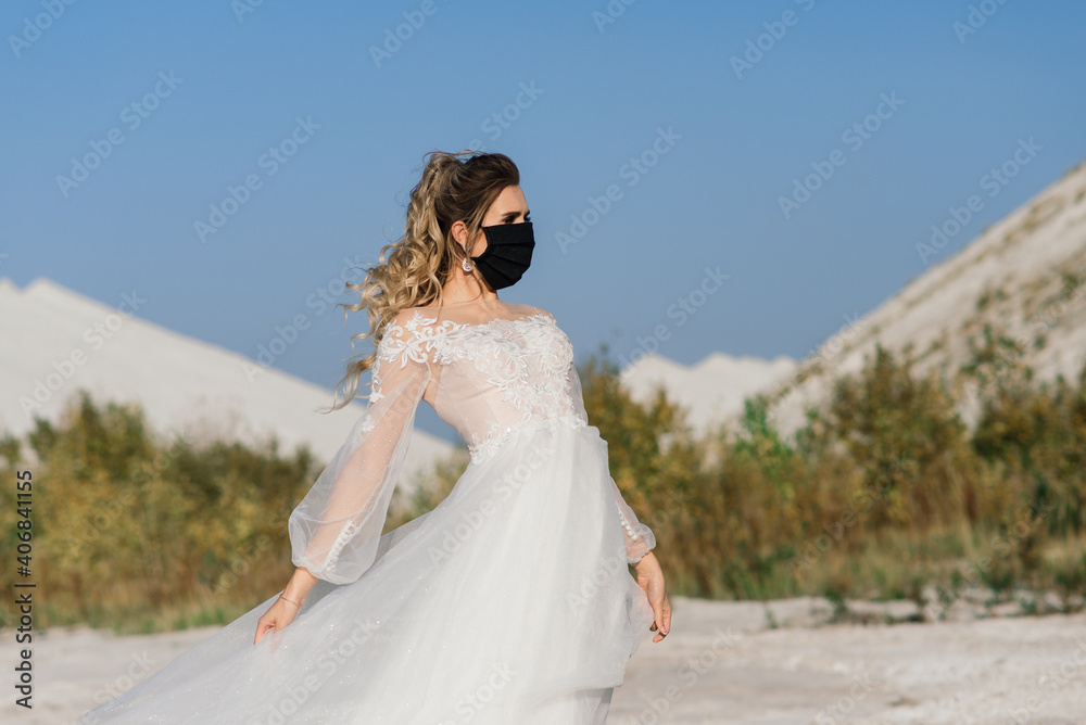 Bride in wedding dress with medical mask at coronavirus covid-19 quarantine period.