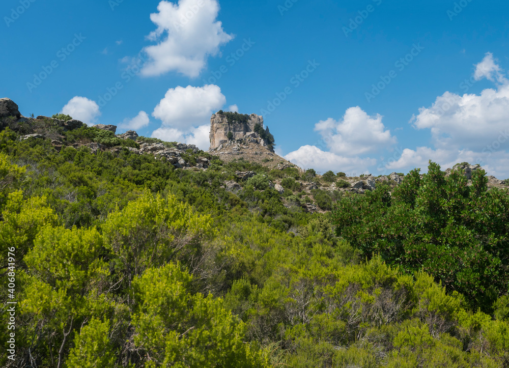 View of limestone tower Perda Liana, impressive rock formation on green forest hill, sardinian table mountain. National Park of Barbagia, Central Sardinia, Italy, summer day