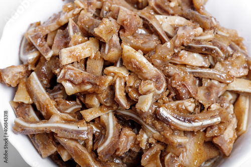 Appetizing beer snack - smoked pork pig ears on a board on a gray background