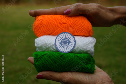 Indian flag tricolor tiranga saffron, white and green embroidery threads. Female palms holding embroidered thread as concept for Indian republic day celebration depicting concept of freedom photo