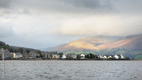 Storm sky. Panoramic view of a small town Rothesay from the water. Country houses and cars close-up. Forests, hills and mountains in the background. Bute Island, Firth of Clyde, Scotland, UK photo