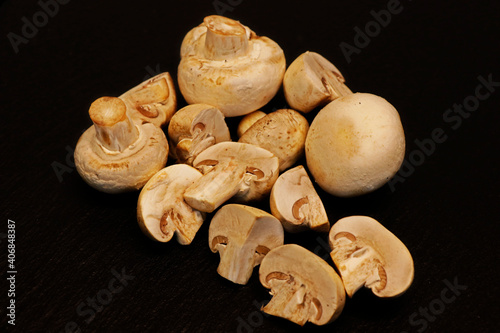 Fresh whole white button mushrooms, or agaricus on black background