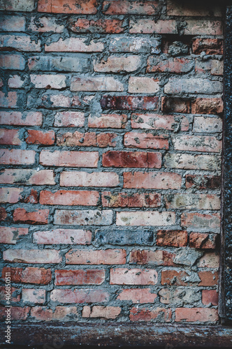 Old red brick wall, rough texture outdoors, weathered surface close-up, vertical photography.